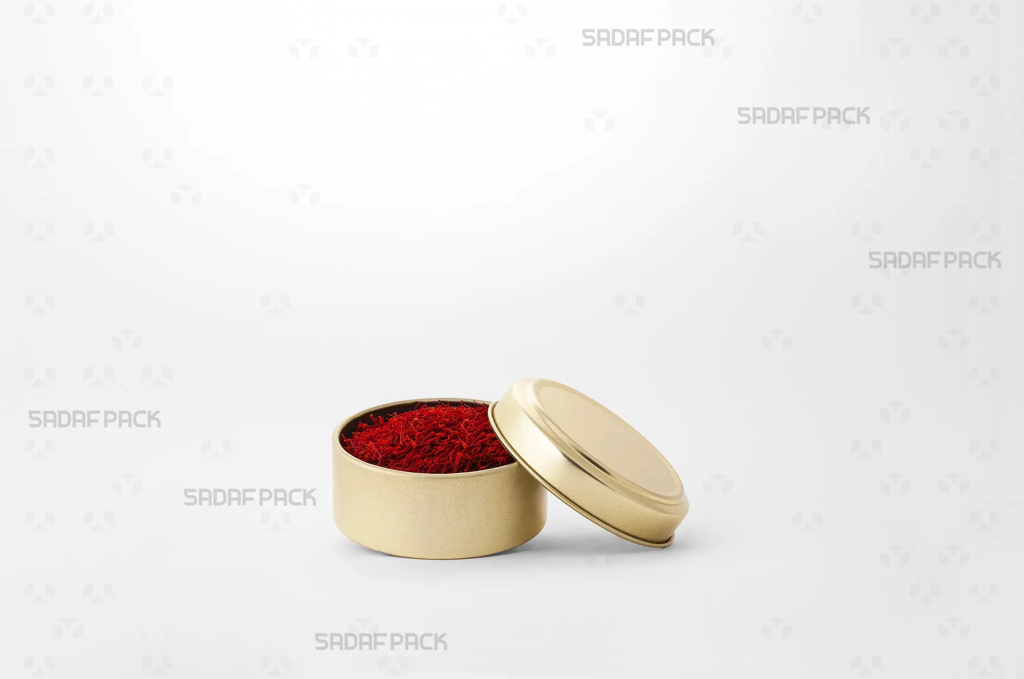 قوطی فلزی گرد طلایی 6.5 سانتی متری صدف پک پر شده با زعفران ایرانی، مناسب برای بستهبندی صادراتی و حفظ تازگی محصول