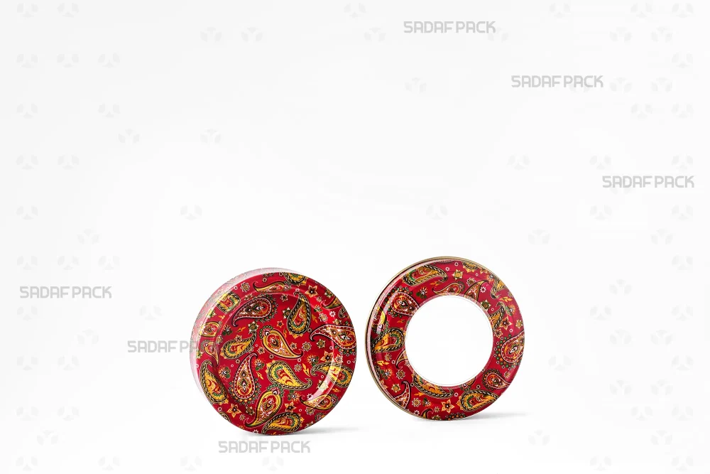 قوطی فلزی 5 گرمی طرح ترمه قرمز با درب باز شده در کنار بدنه، نمایش فضای داخلی برای نگهداری زعفران