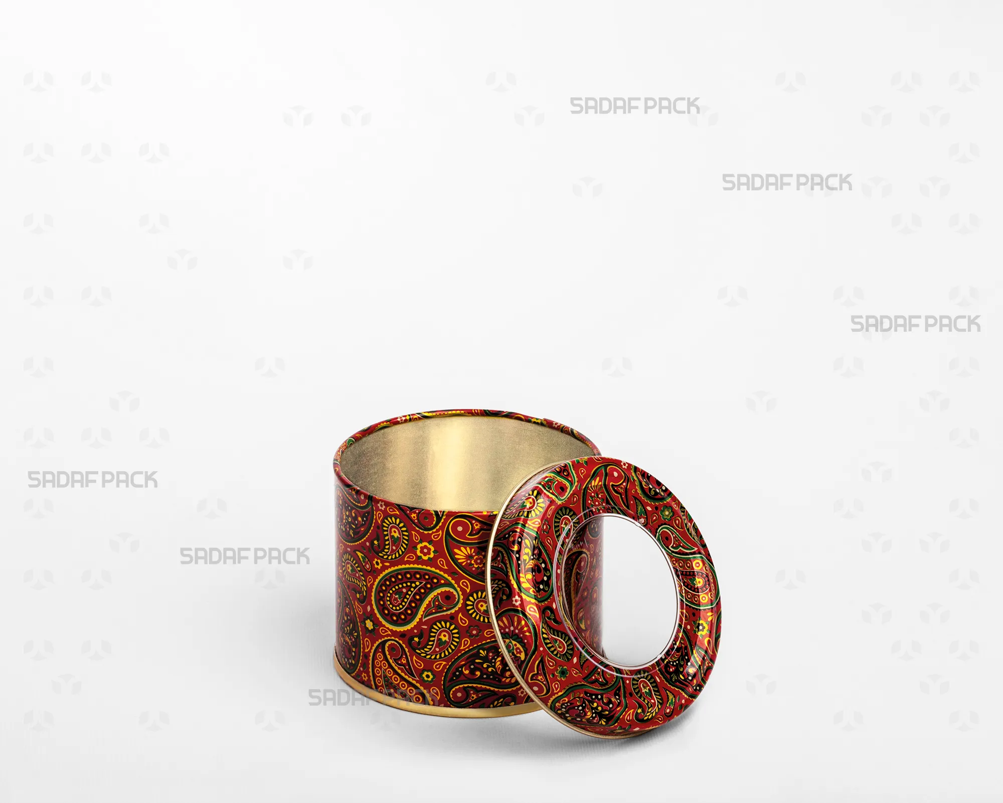 تصویر سه رخ از قوطی فلزی ۷ سانت با ارتفاع ۵ سانت و طرح ترمه قرمز صدف پک، که درب شفاف آن باز شده و کنار بدنه قرار گرفته تا فضای داخلی آن دیده شود.