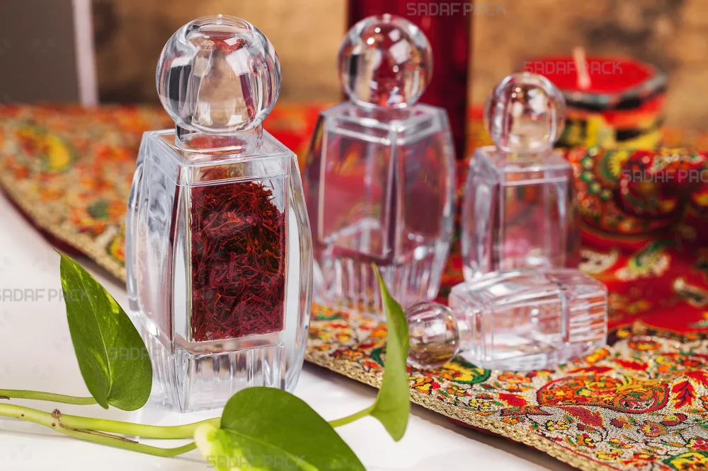 مجموعه ظروف صدف کف بالا صدف پک در سایزهای مختلف بر روی پارچه با برگ گیاه، تمرکز بر ظرف بزرگ پر شده با زعفران