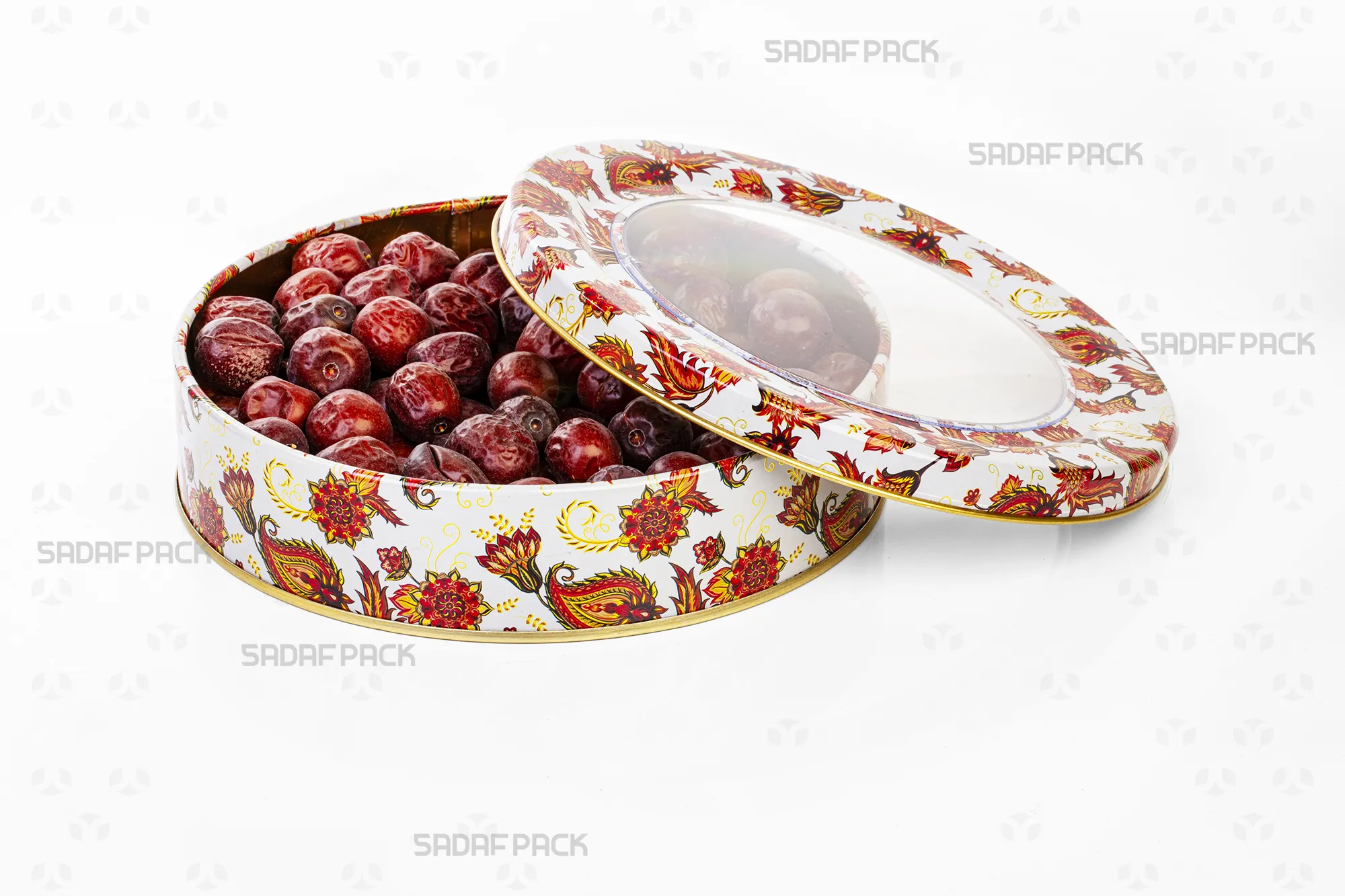 نمای بالا از قوطی فلزی 17 سانتی متری صدف پک با درب باز، طرح ترنج سفید، که با عناب پر شده است و ظرفیت داخلی قوطی را نمایش میدهد.