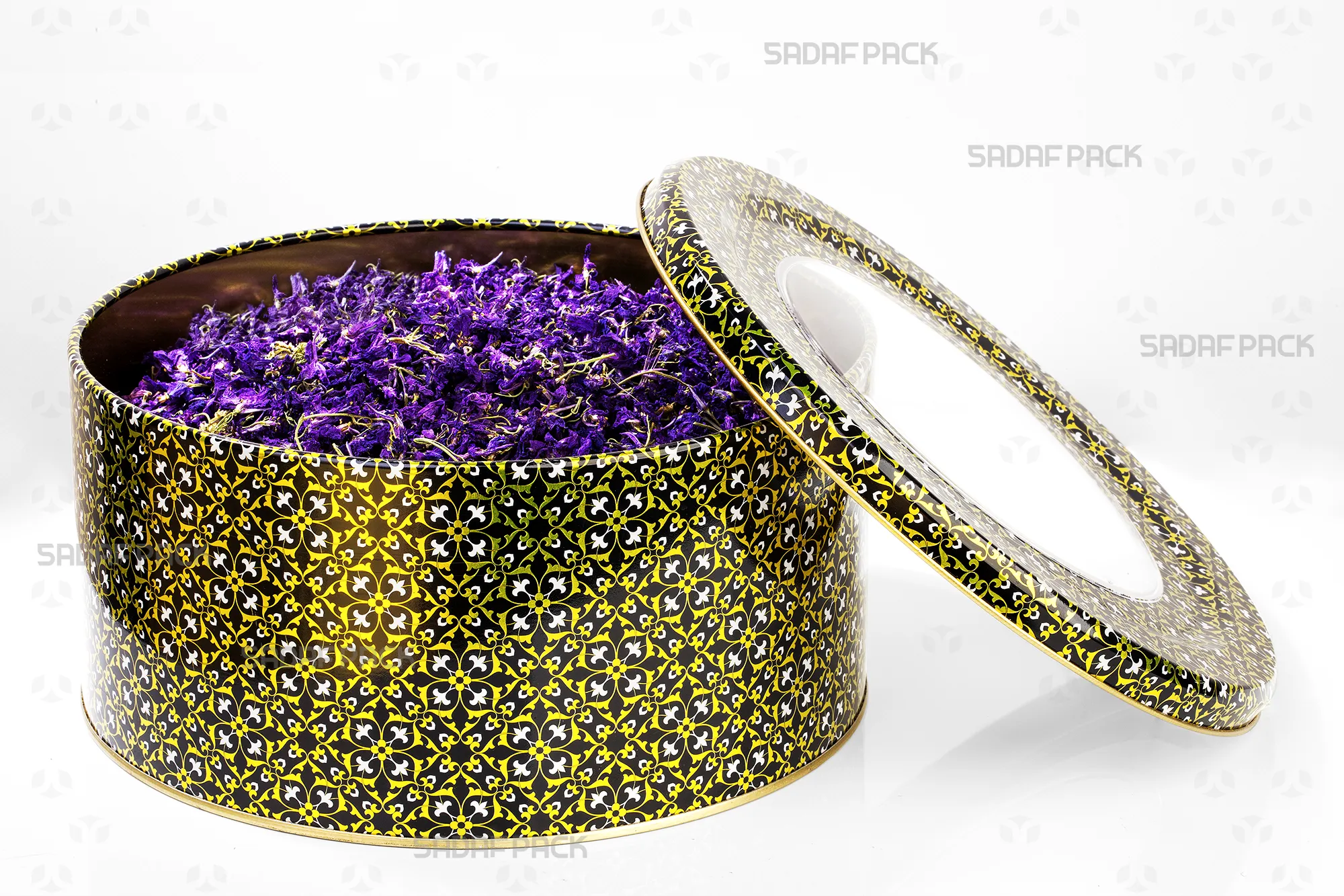 قوطی فلزی گرد 23 در 10 سانت طرح مشکی طلایی سفید صدف پک، نمای بالا با درب باز که با گل گاوزبان پر شده و ظرفیت آن را نمایش میدهد.