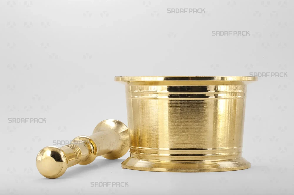 هاون برنجی سنتی سایز 130 به همراه دسته آن در کنارش، نمایشگر بدنه استوانه‌ای و مستحکم با جزئیات خطوط حکاکی شده برای کارهای سنگین.